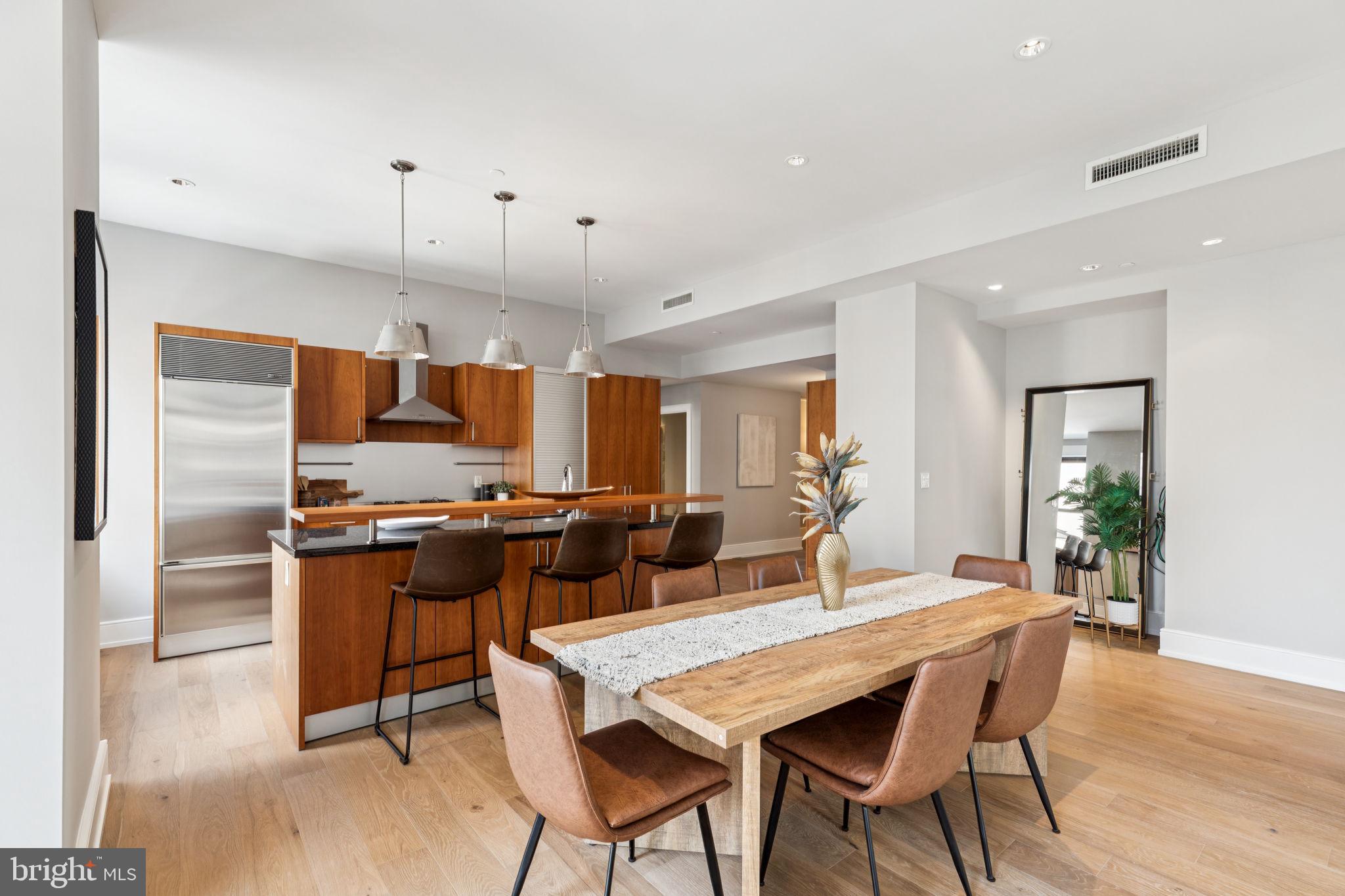 1515 Locust Street, Unit 800 Philadelphia, PA 19102 - Photo 5 of 59 a kitchen with stainless steel appliances kitchen island granite countertop a table chairs and a refrigerator