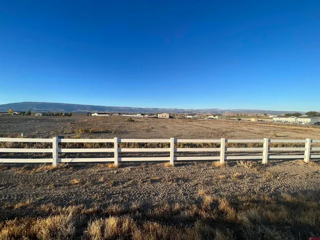 a view of a yard with wooden fence