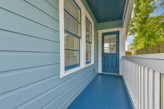 a view of a house with a yard and large tree