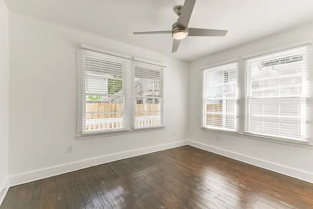 a kitchen with granite countertop a sink stainless steel appliances white cabinets and a window