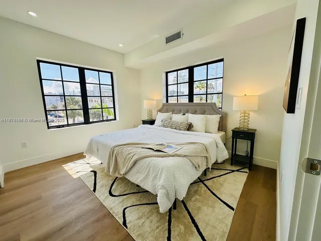 a bedroom with a bed window and a wall painting
