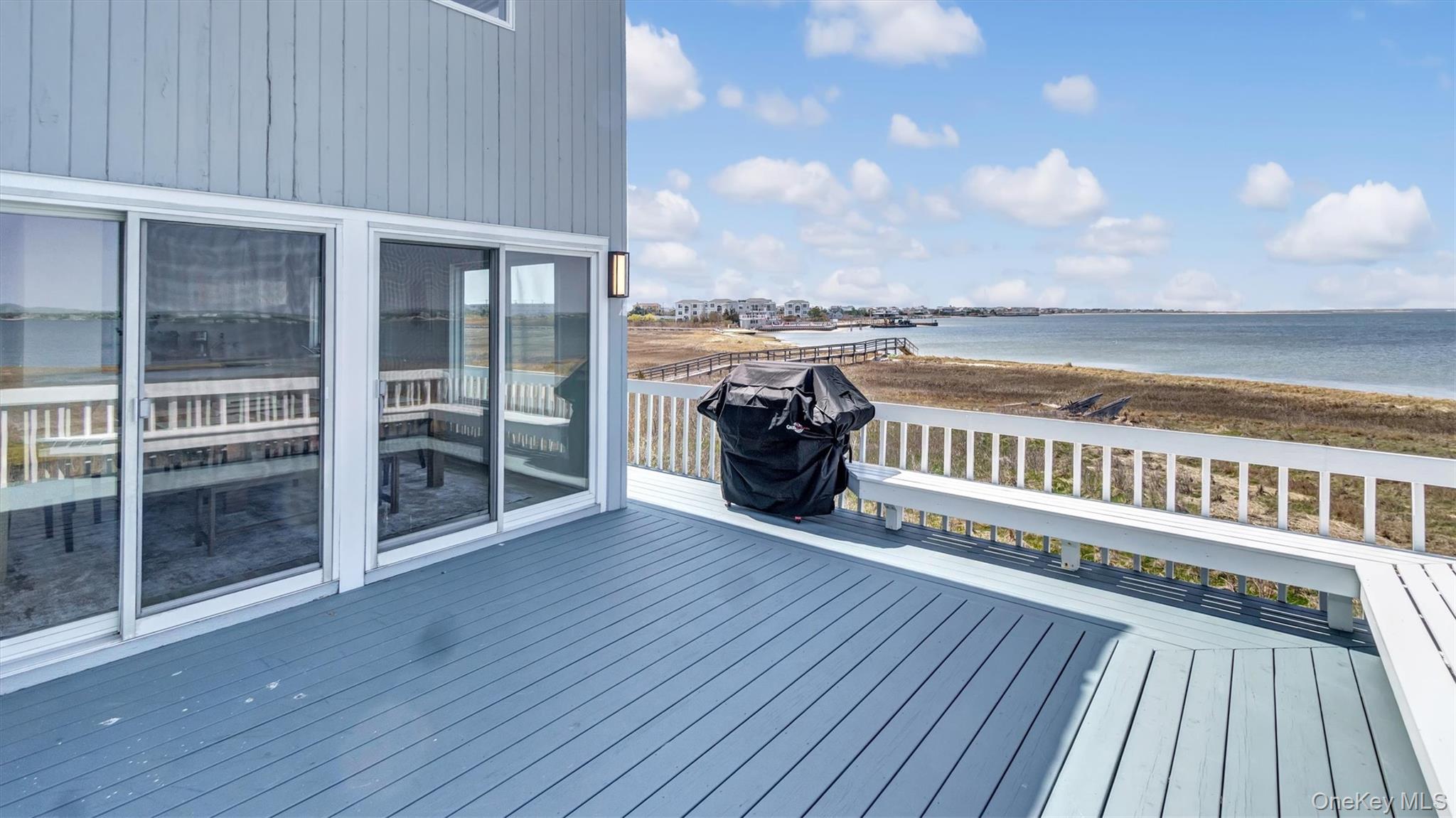 552 Dune Road Westhampton, NY 11978 - Photo 14 of 32 a view of a balcony with wooden floor and fence