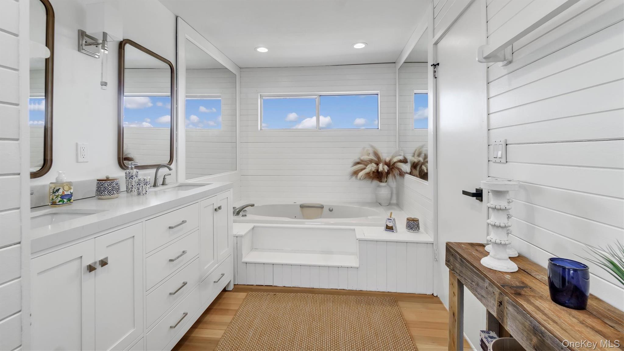 552 Dune Road Westhampton, NY 11978 - Photo 19 of 32 a bathroom with a tub sink and mirror