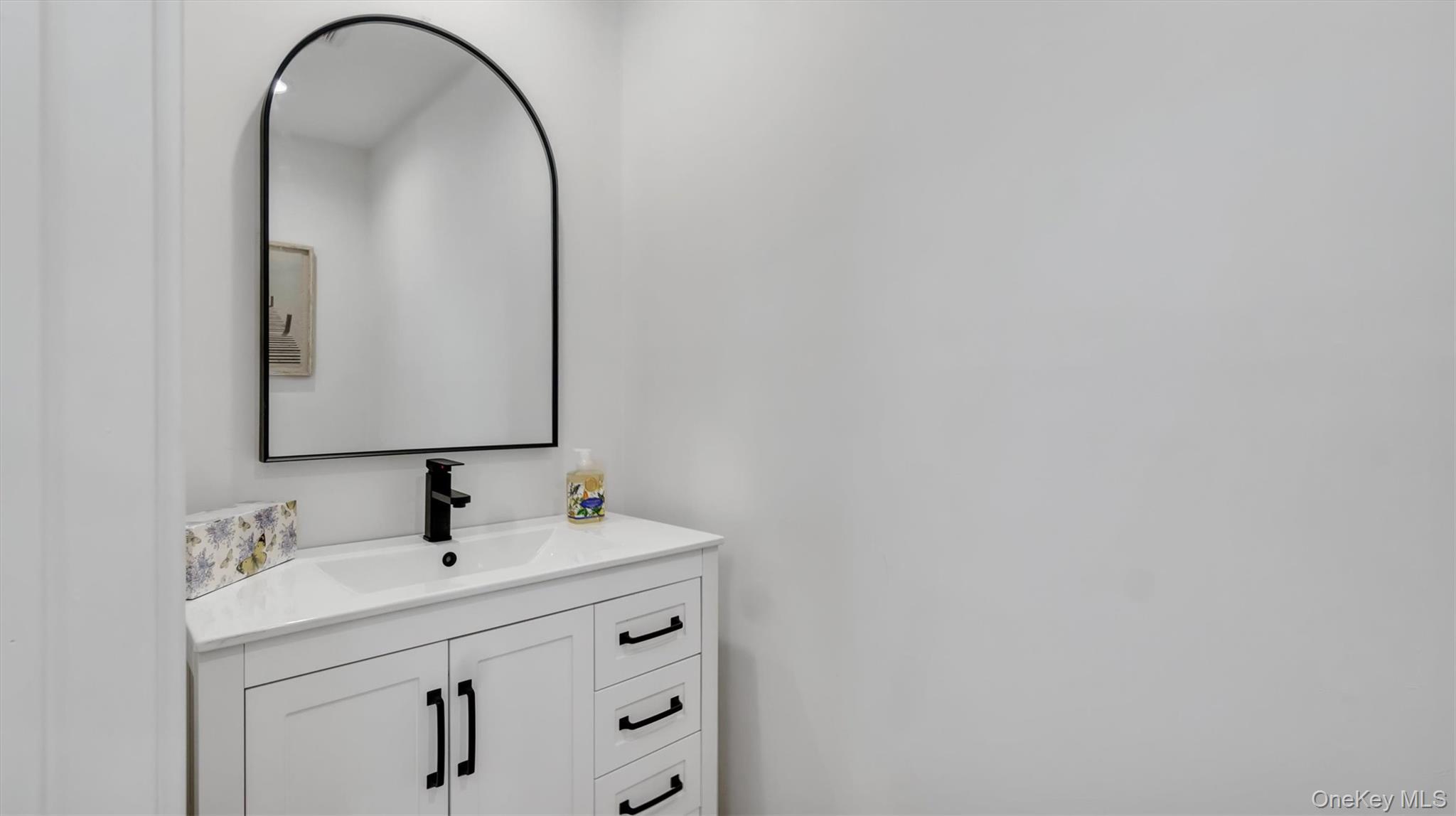 552 Dune Road Westhampton, NY 11978 - Photo 21 of 32 a bathroom with a sink and a mirror