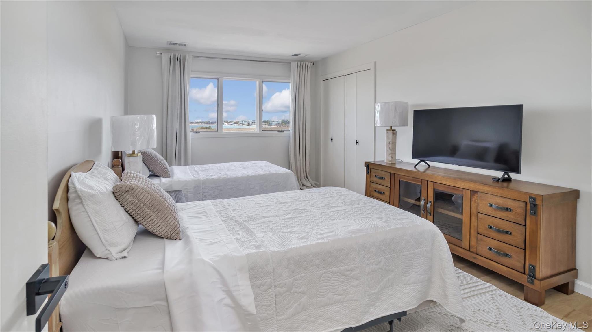 552 Dune Road Westhampton, NY 11978 - Photo 30 of 32 a bedroom with a bed and a flat screen tv