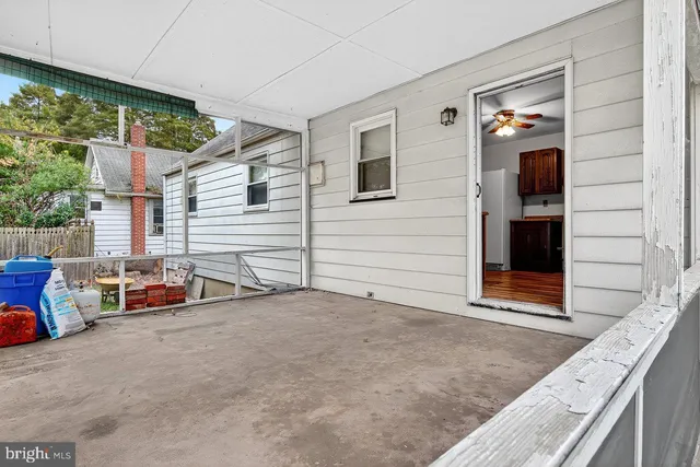 a view of a room with a large window and wooden floor