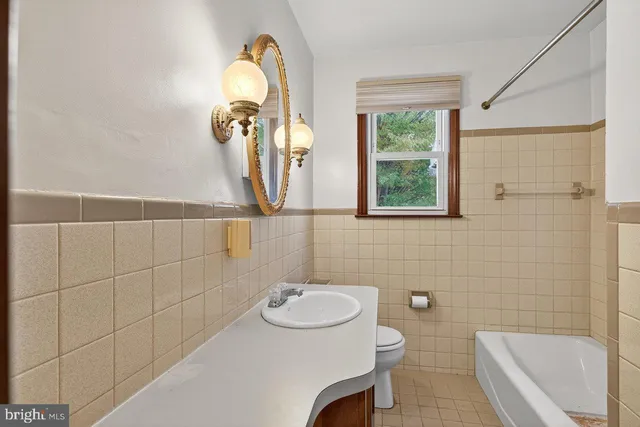 a view of an empty room with window and a chandelier fan
