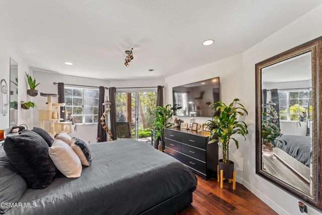 a bedroom with bed and wooden floor