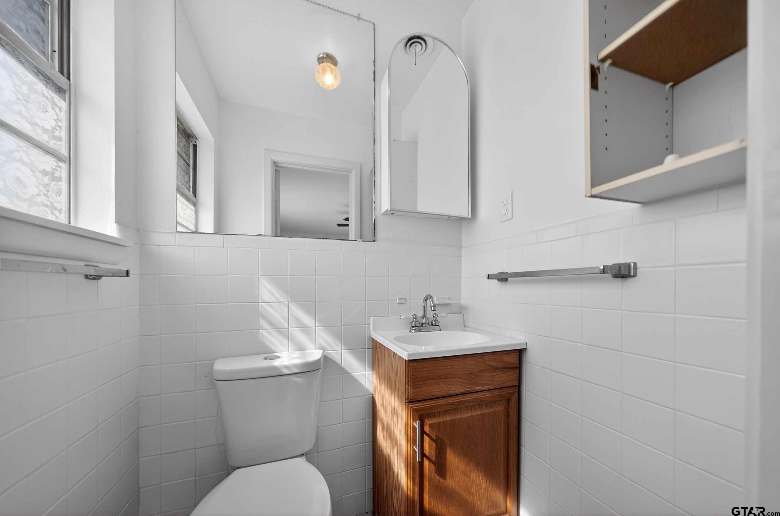 11457 State Highway 64 Tyler, TX 75707 - Photo 28 of 43 a bathroom with a toilet sink and mirror