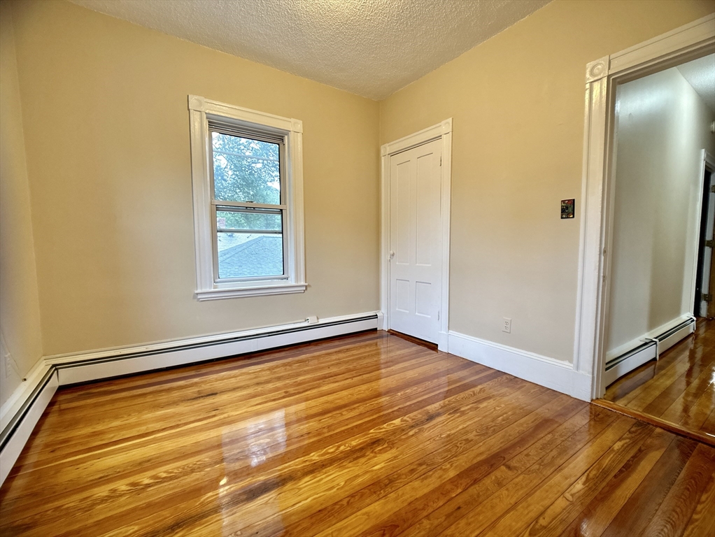 22 Spring Park Avenue, Unit 3 Boston, MA 02130 - Photo 9 of 11 a view of an empty room with wooden floor and a window