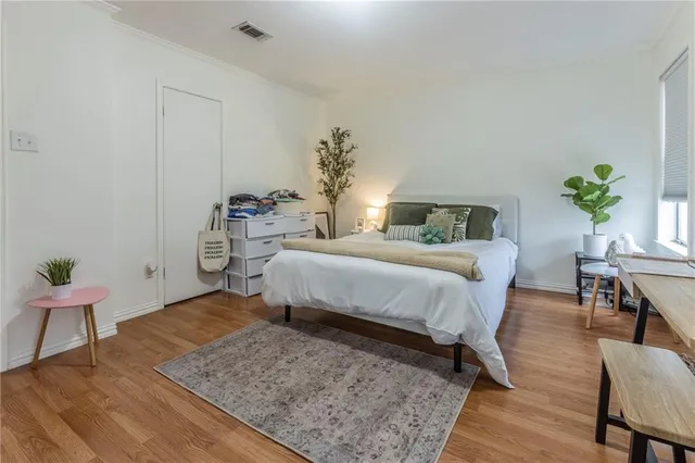 a bedroom with a bed table and chair
