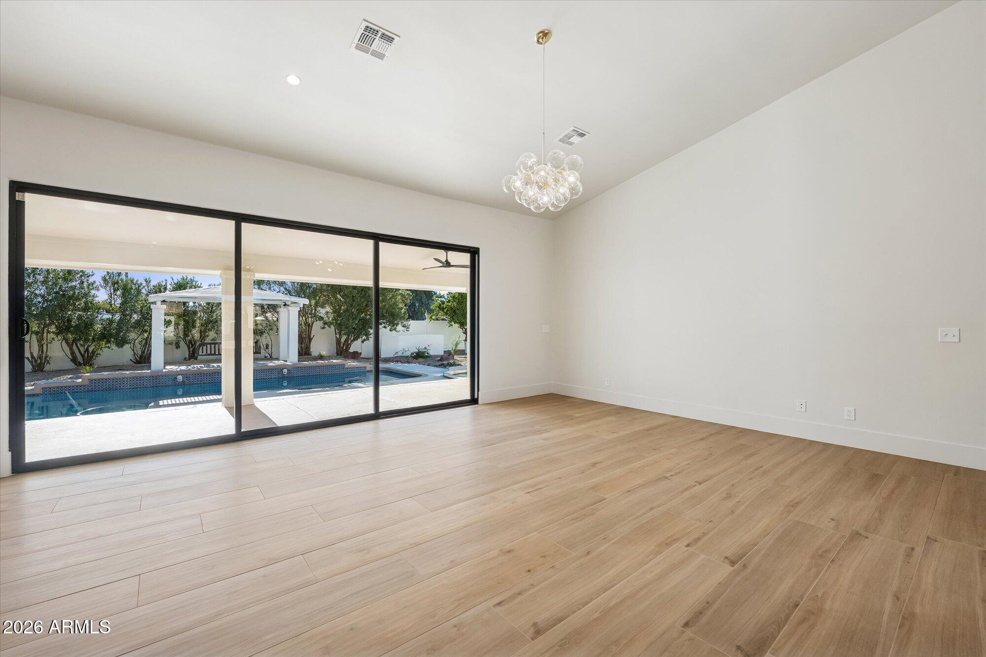 5861 East St John Road Scottsdale, AZ 85254 - Photo 6 of 60 a view of an empty room with wooden floor and a window