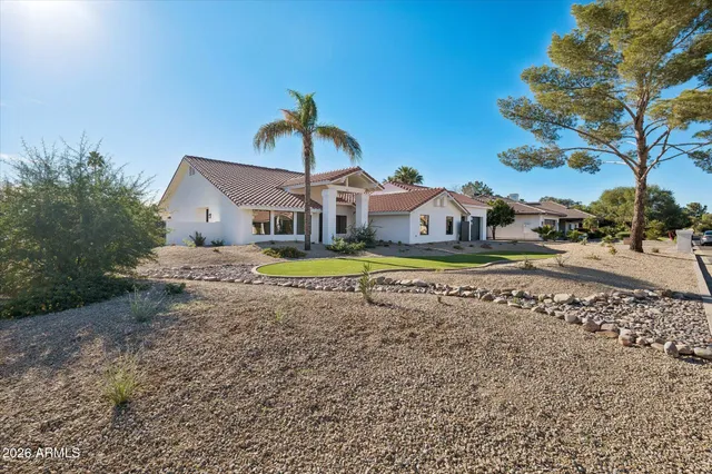 a view of a house with a big yard and large trees