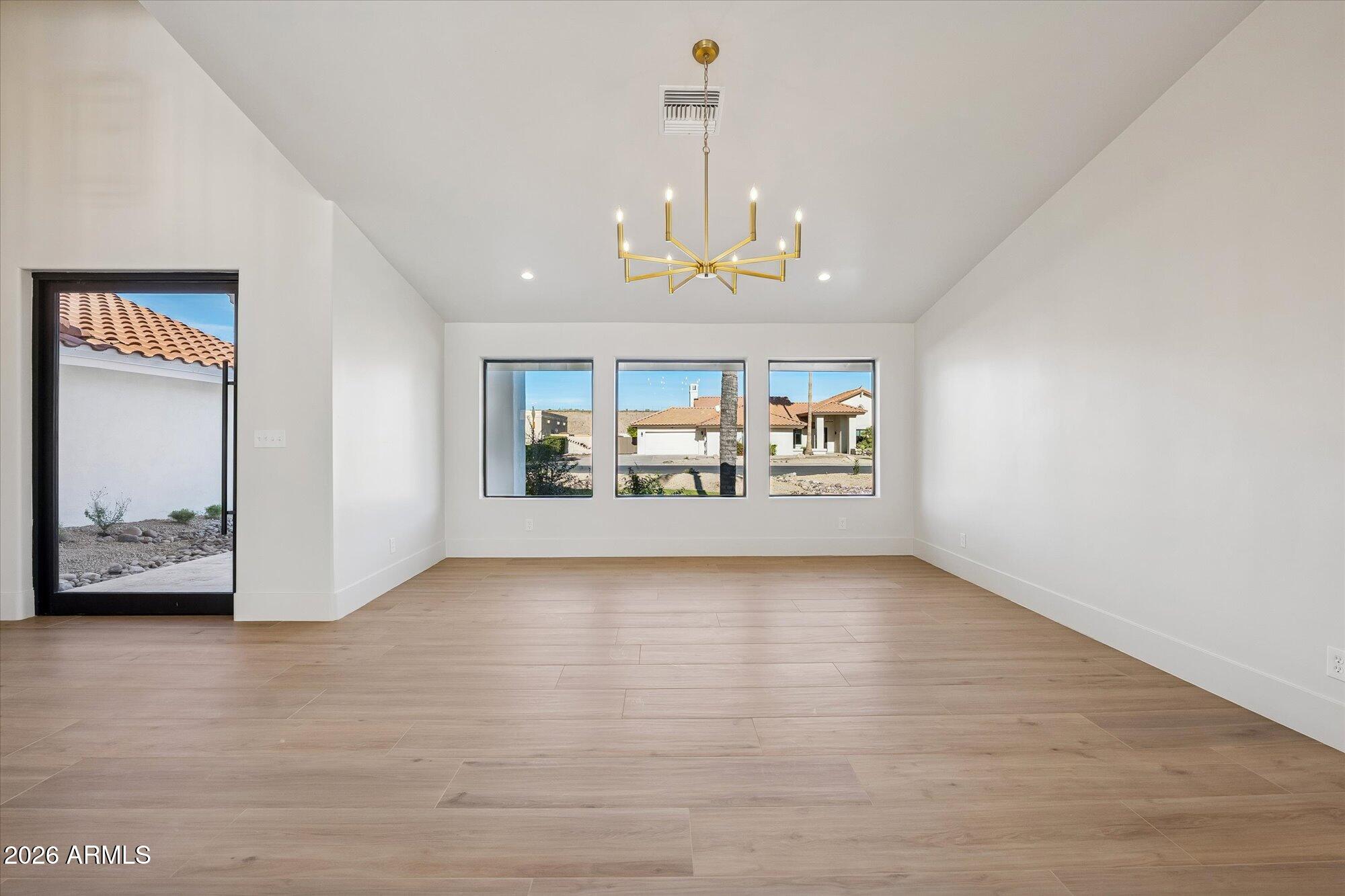 5861 East St John Road Scottsdale, AZ 85254 - Photo 13 of 60 a view of a hallway with wooden floor and a chandelier