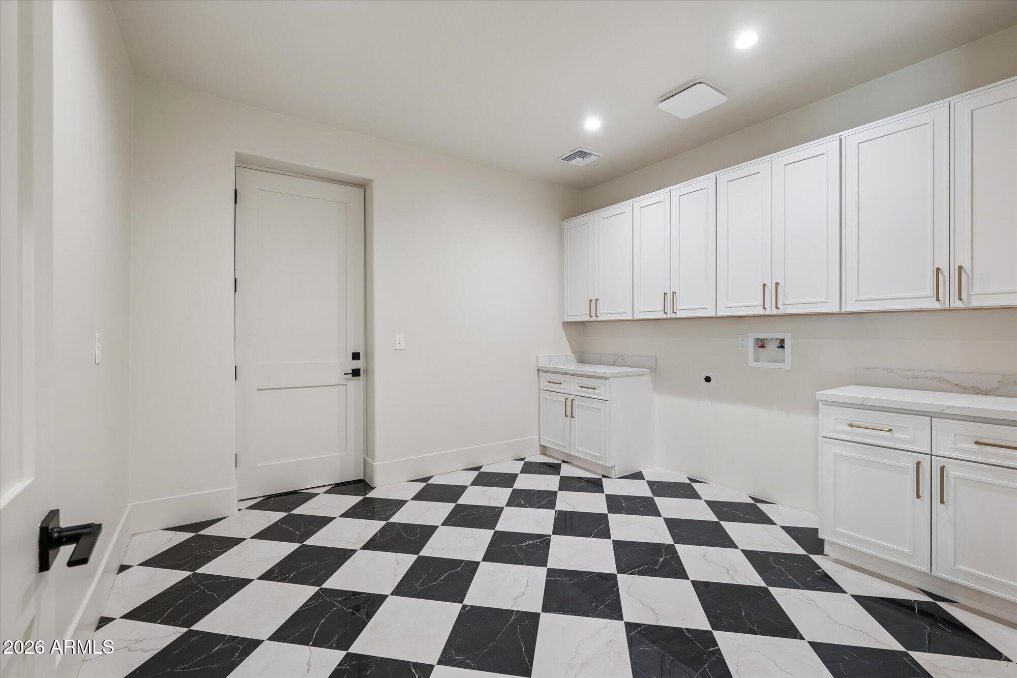5861 East St John Road Scottsdale, AZ 85254 - Photo 23 of 60 a kitchen with a checkered floor and white cabinets