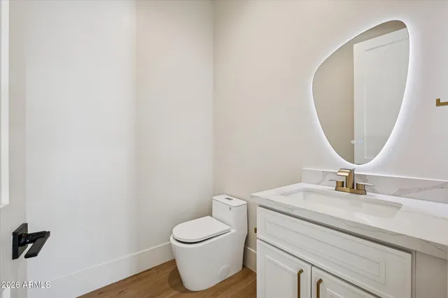 a view of an empty room with chandelier and wooden floor