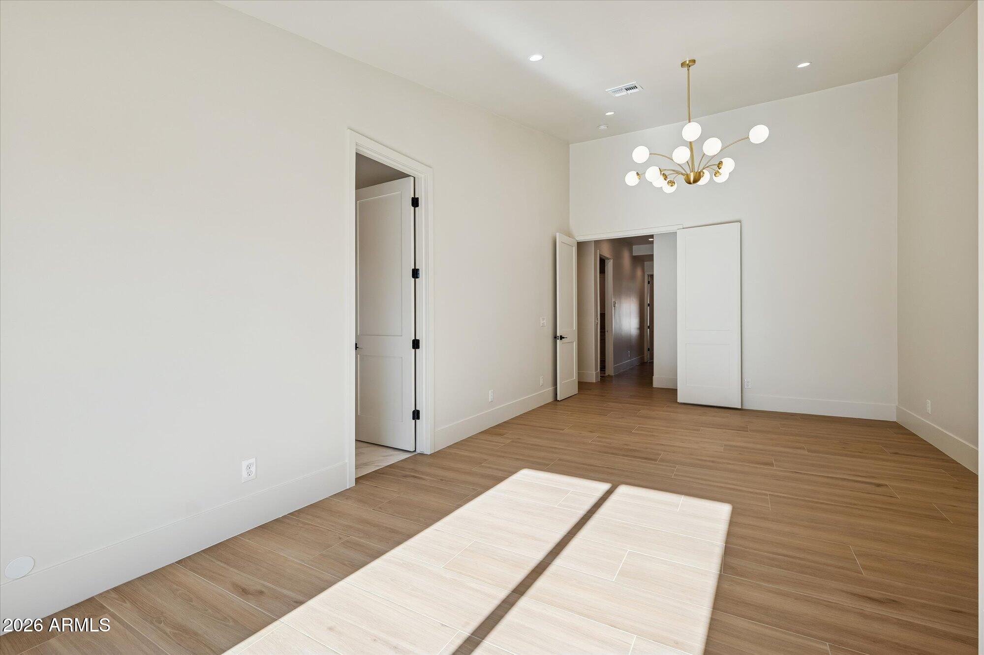 5861 East St John Road Scottsdale, AZ 85254 - Photo 26 of 60 a view of an empty room with chandelier and wooden floor