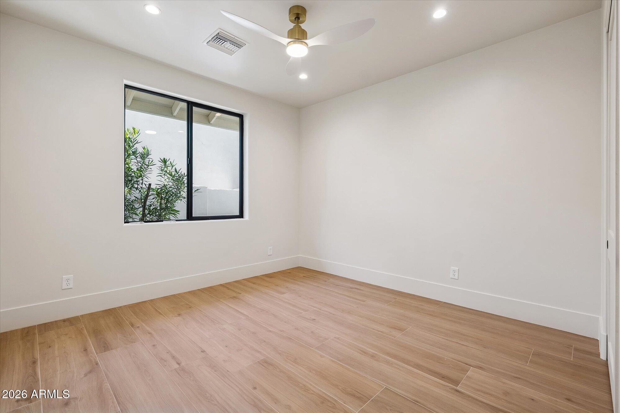 5861 East St John Road Scottsdale, AZ 85254 - Photo 37 of 60 an empty room with wooden floor chandelier fan and windows
