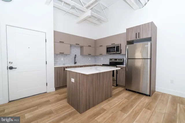 a kitchen with stainless steel appliances a refrigerator and a stove top oven