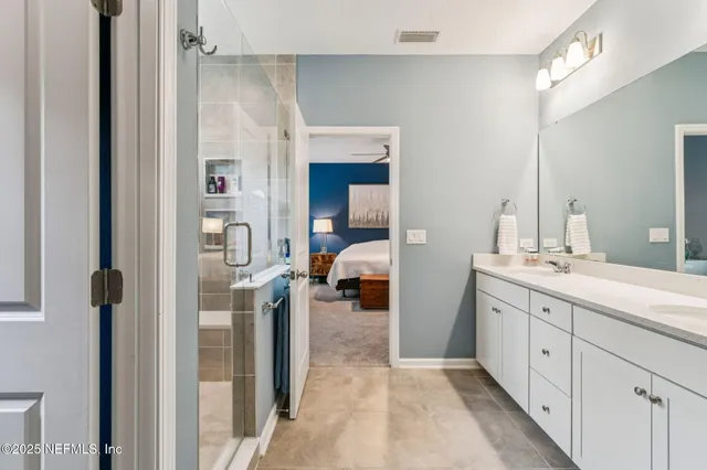 a en suite bathroom with a double vanity sink and a mirror