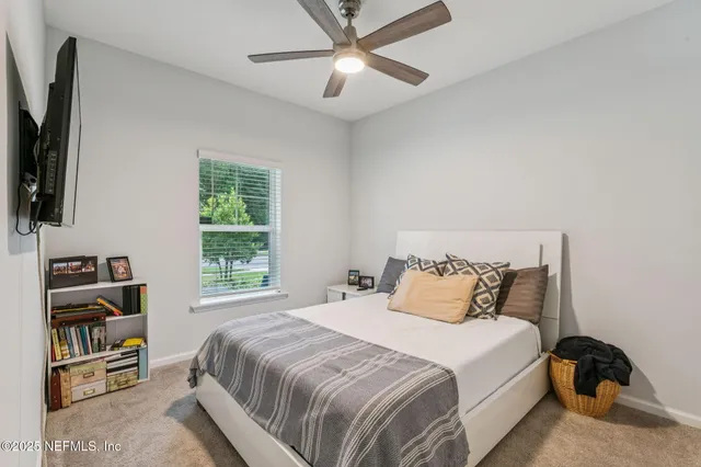 a bedroom with a bed and a flat tv screen on the dresser
