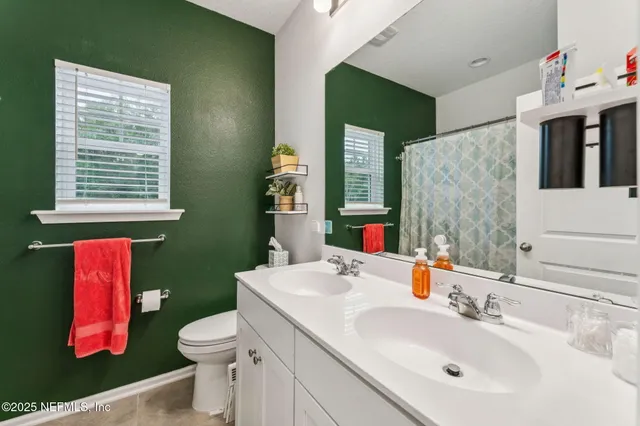 a bathroom with a sink vanity mirror and toilet
