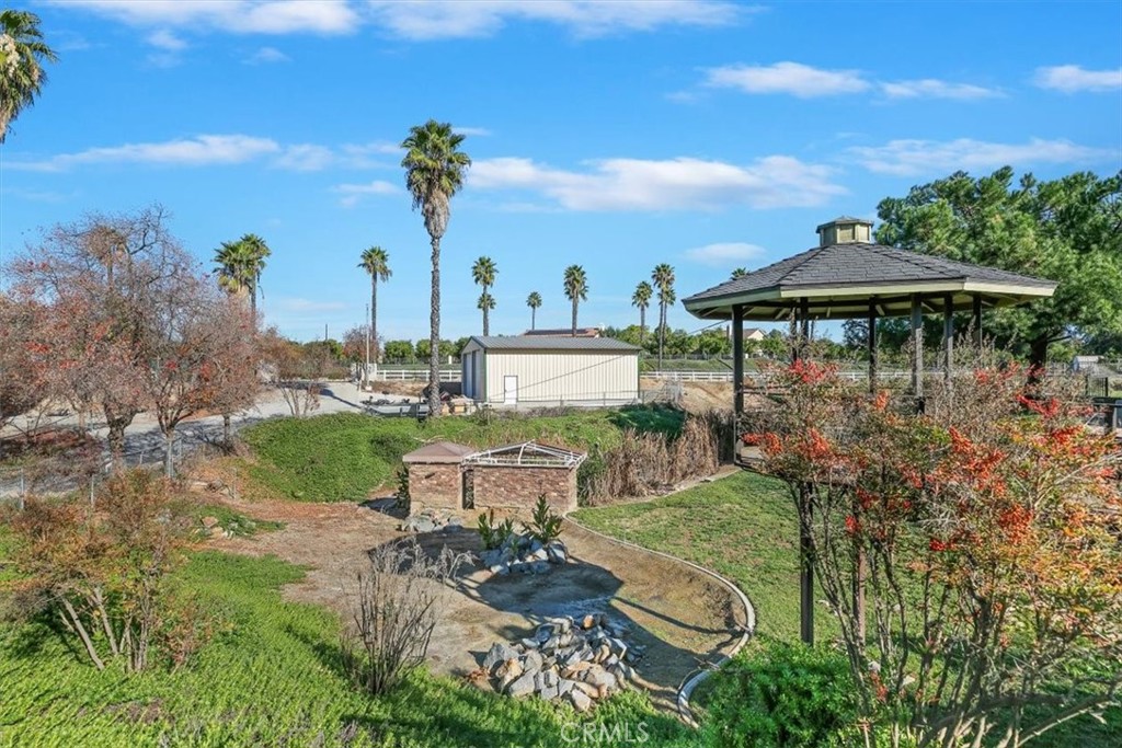 18590 Roberts Road Riverside, CA 92508 - Photo 47 of 66 a view of a garden with a table and chairs under an umbrella