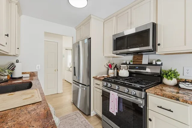 a kitchen with stainless steel appliances a stove a microwave and a refrigerator