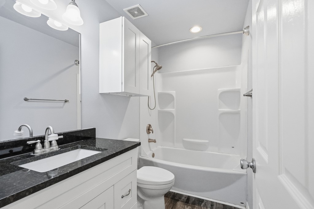 2121 Lone Star Road Rockport, TX 78382 - Photo 14 of 29 a bathroom with a granite countertop sink a toilet a mirror and shower