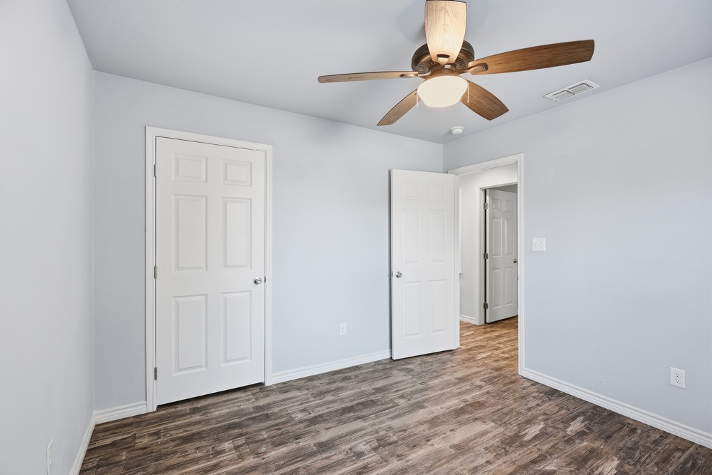 2121 Lone Star Road Rockport, TX 78382 - Photo 21 of 29 wooden floor in an empty room with a chandelier fan