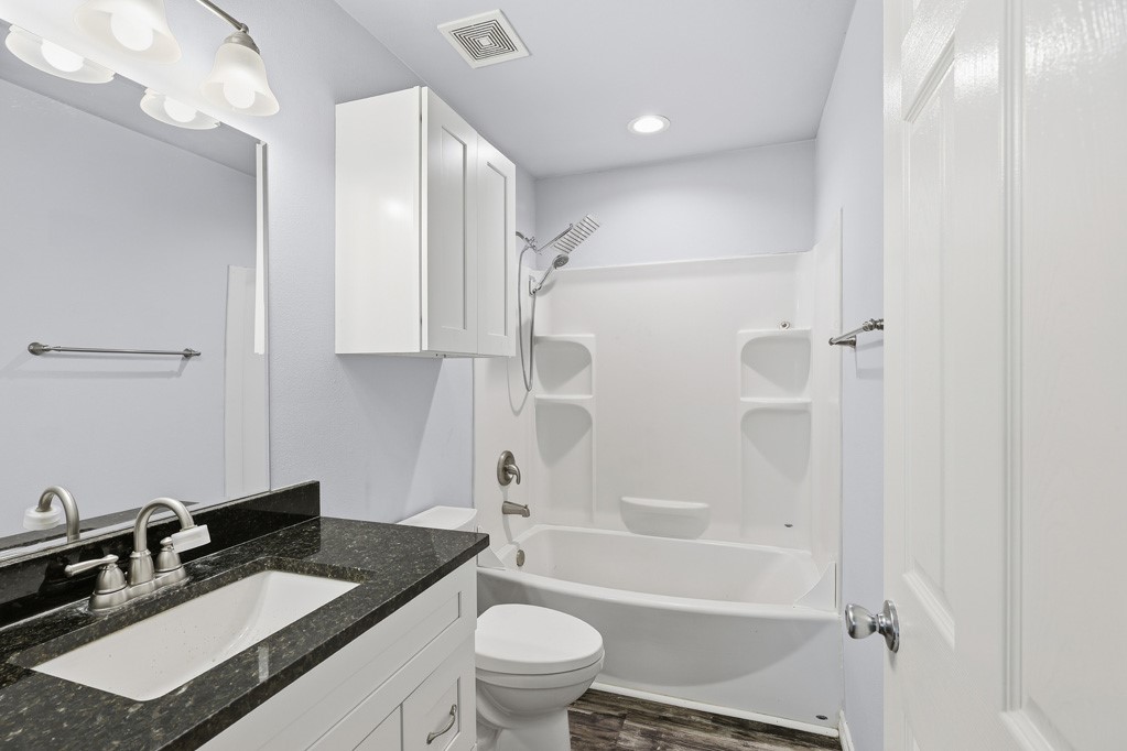 2121 Lone Star Road Rockport, TX 78382 - Photo 22 of 29 a bathroom with a granite countertop sink toilet a mirror and shower