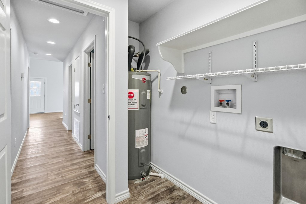 2121 Lone Star Road Rockport, TX 78382 - Photo 24 of 29 a hallway with white cabinets and wooden floor