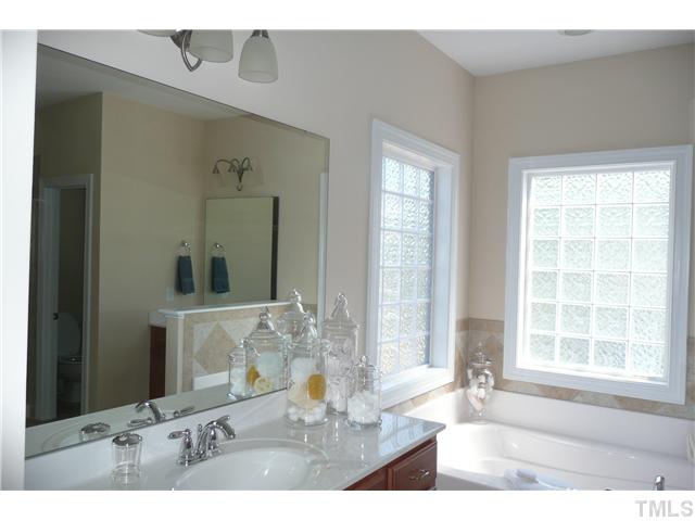 2755 Hidden Waters Circle Raleigh, NC 27614 - Photo 12 of 19 Luxurious master bath has separate his/her vanities, corner tub surrounded by two glass block windows, separate shower and water closet, all accented with lovely tile flooring and surround