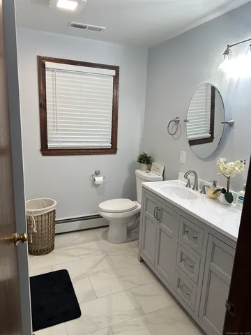 a bathroom with a toilet a sink and mirror