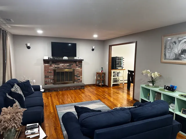 a living room with furniture a flat screen tv and a fireplace