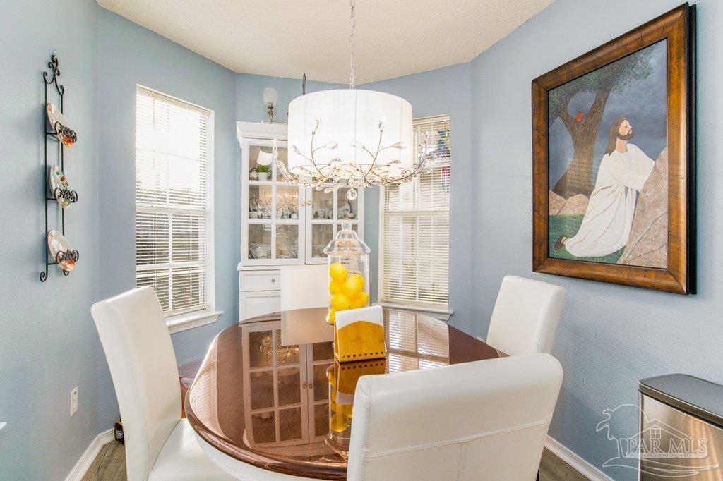 2466 Redoubt Avenue Pensacola, FL 32507 - Photo 9 of 27 a view of a dining room with furniture wooden floor and a chandelier