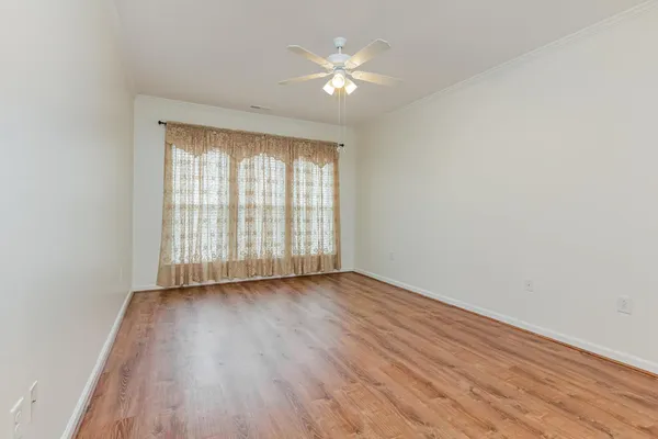 an empty room with wooden floor and windows