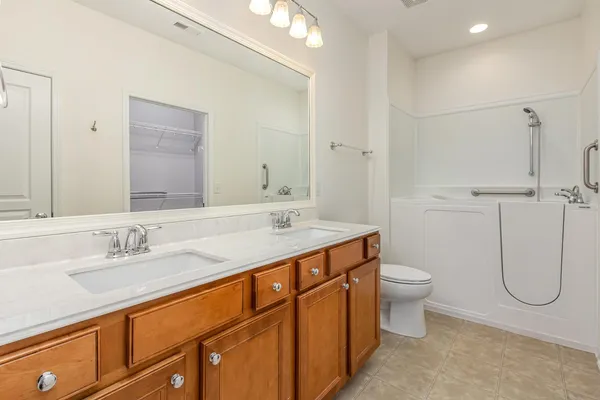 a bathroom with a granite countertop toilet sink and mirror