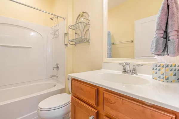 a bathroom with a granite countertop sink a toilet and shower