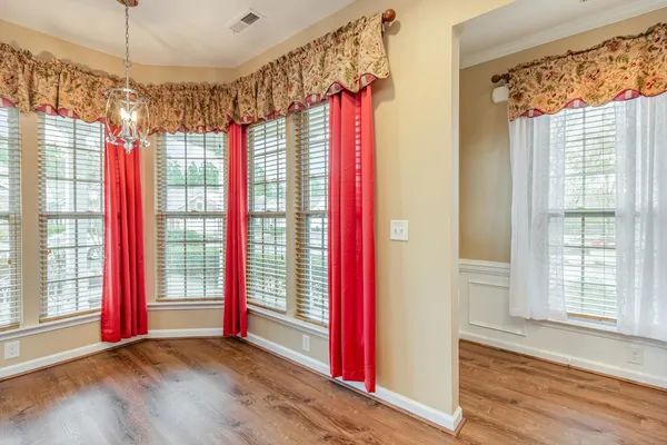 a view of an empty room with a birdcage and a window