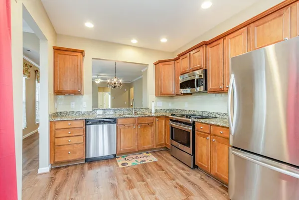 a kitchen with stainless steel appliances granite countertop a refrigerator stove and sink