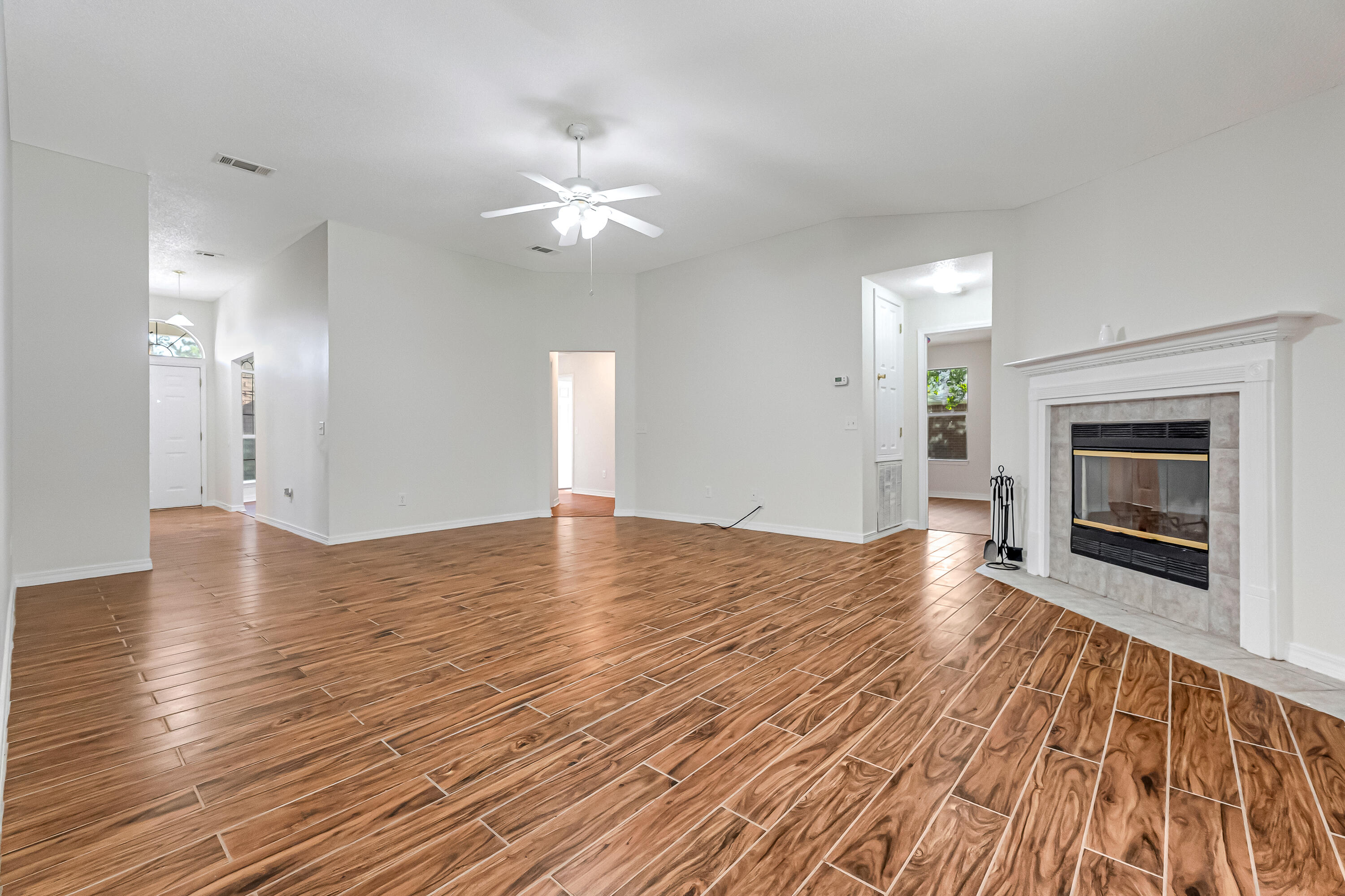 427 Hatchee Drive Crestview, FL 32536 - Photo 12 of 77 an empty room with wooden floor fireplace and windows