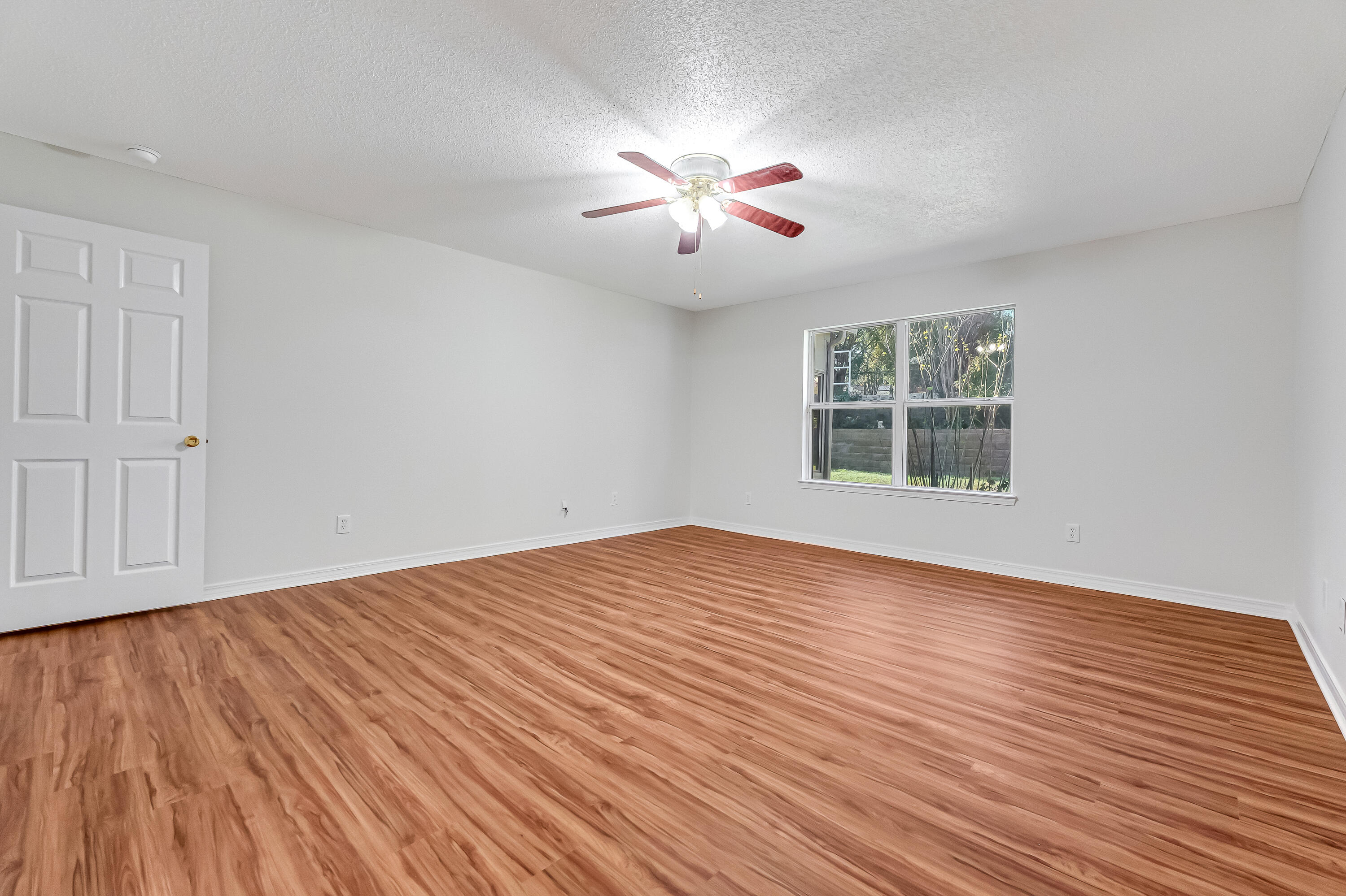 427 Hatchee Drive Crestview, FL 32536 - Photo 29 of 77 a view of an empty room with wooden floor and a window