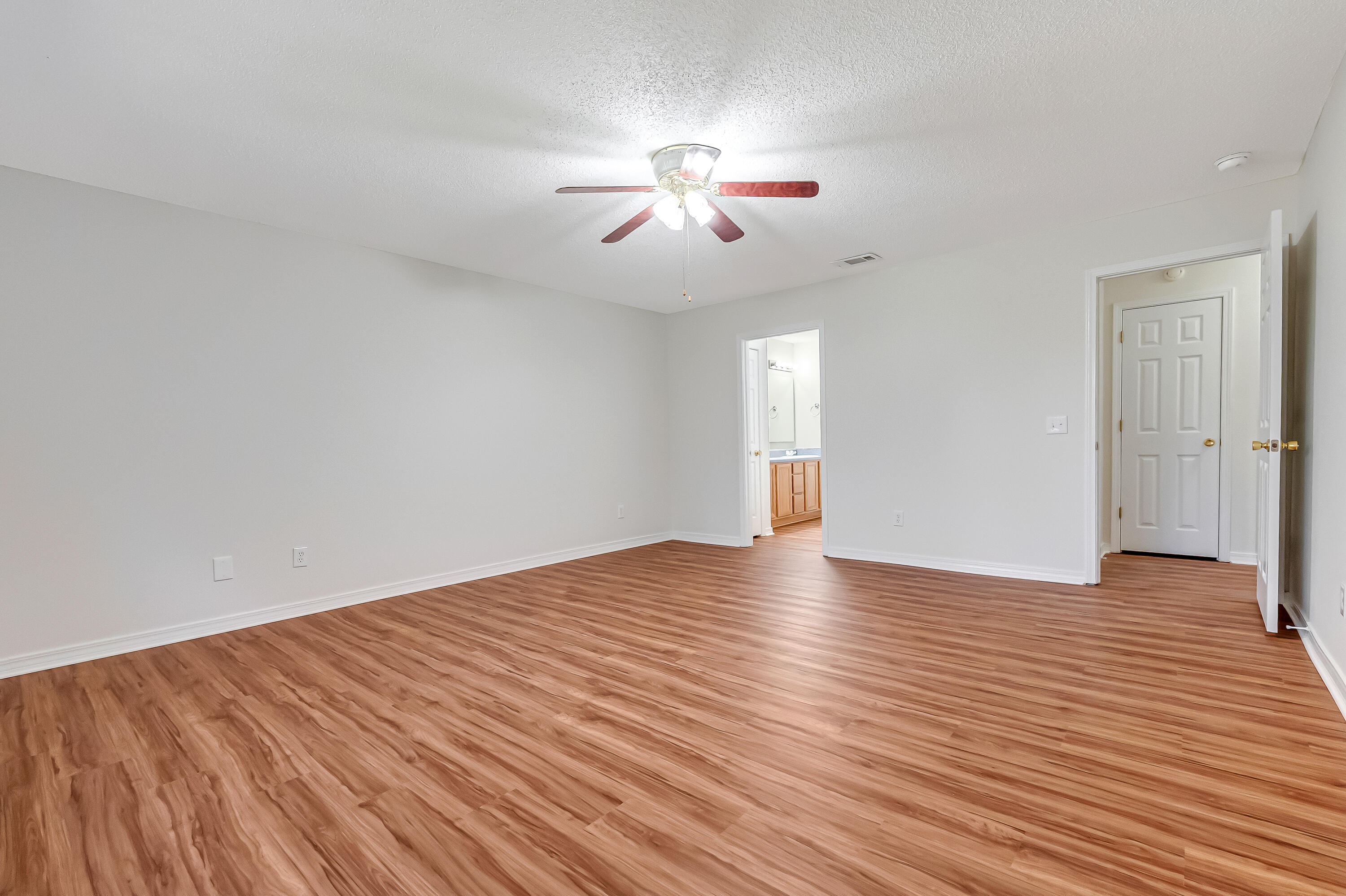 427 Hatchee Drive Crestview, FL 32536 - Photo 31 of 77 a view of an empty room with wooden floor and a ceiling fan
