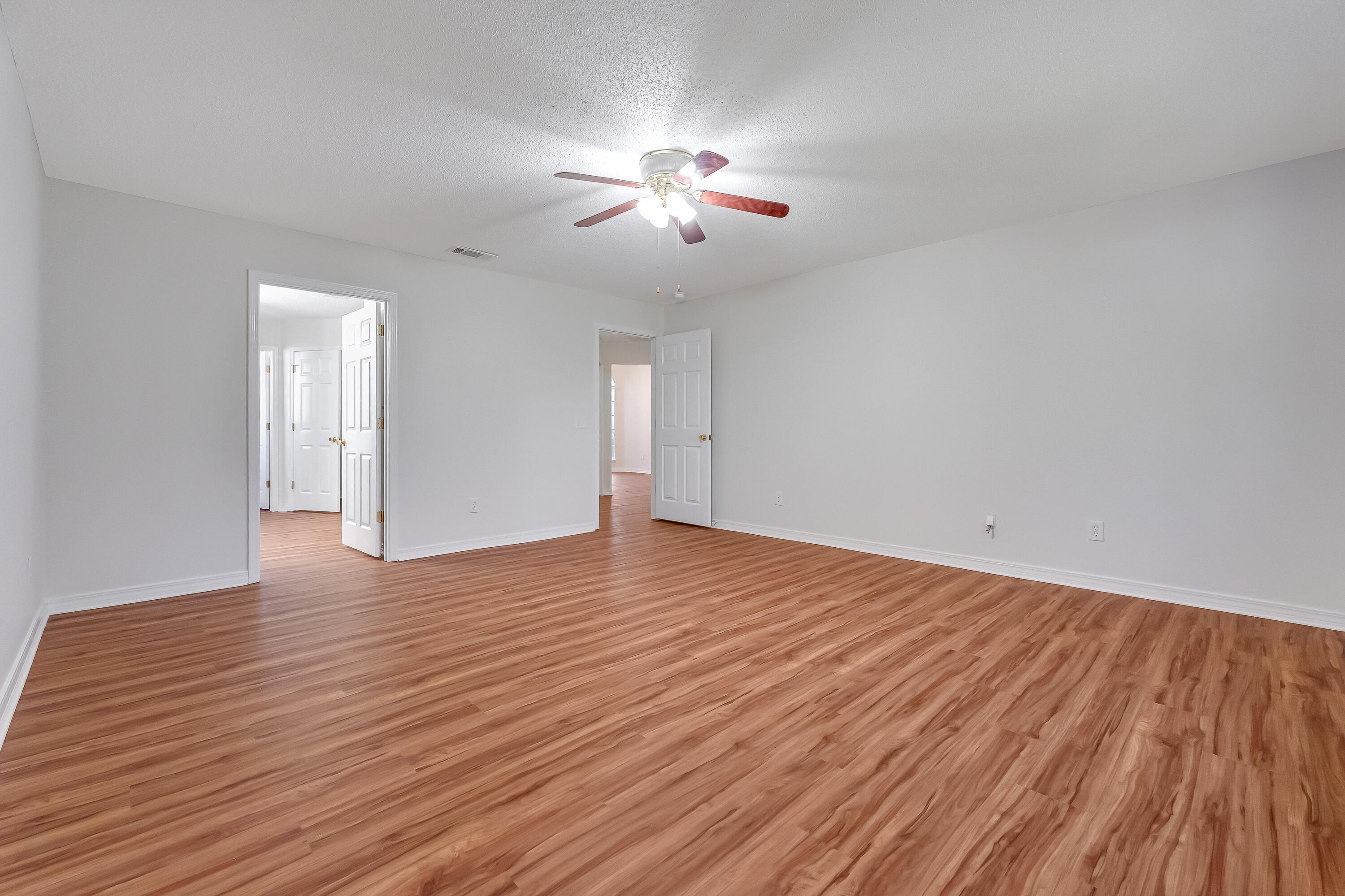 427 Hatchee Drive Crestview, FL 32536 - Photo 32 of 77 a view of an empty room with wooden floor and a chandelier fan