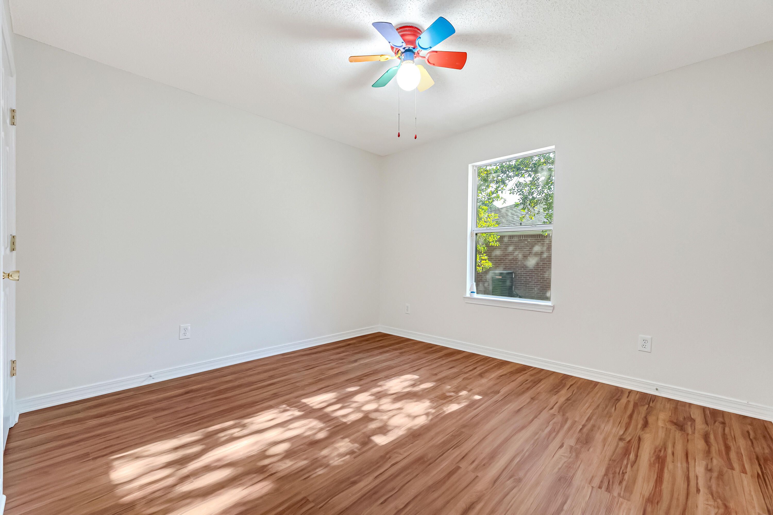 427 Hatchee Drive Crestview, FL 32536 - Photo 42 of 77 a view of an empty room with window and wooden floor