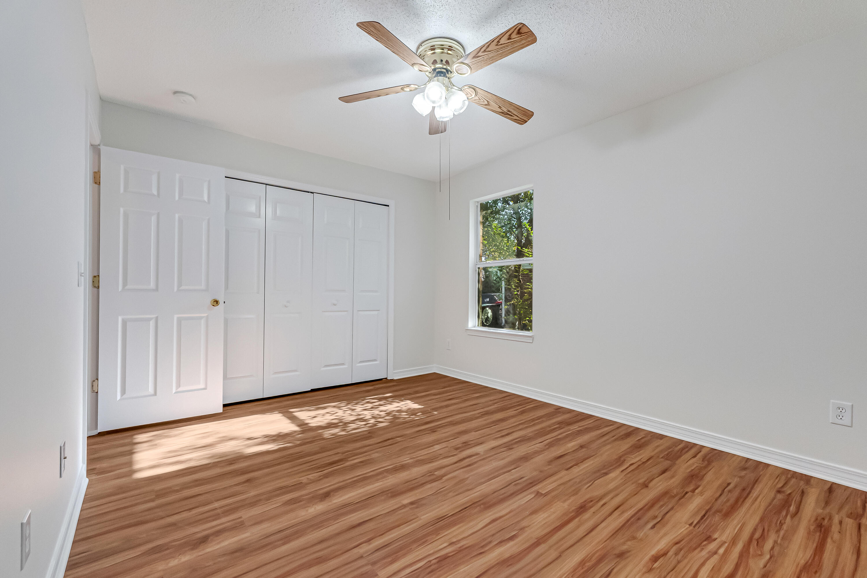 427 Hatchee Drive Crestview, FL 32536 - Photo 47 of 77 a view of an empty room with window and wooden floor