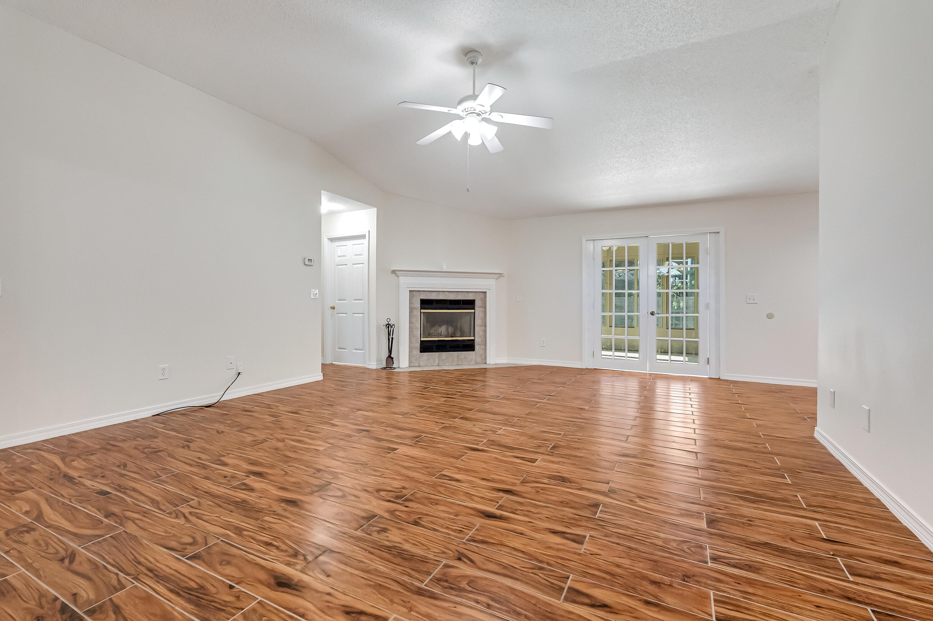 427 Hatchee Drive Crestview, FL 32536 - Photo 7 of 77 a view of an empty room with wooden floor and a window