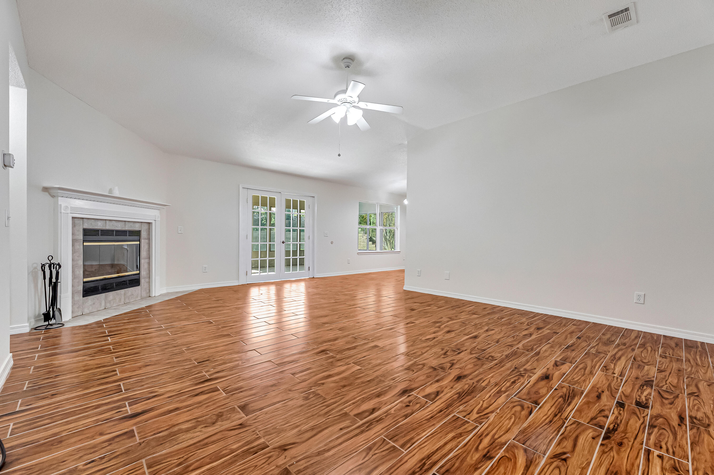 427 Hatchee Drive Crestview, FL 32536 - Photo 8 of 77 a view of empty room with wooden floor and fan