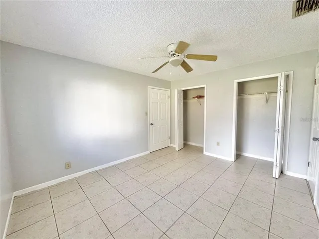 an empty room with fan and windows